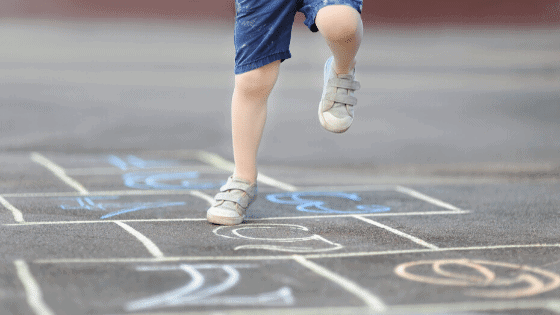 child playing hopscotch on the driveway