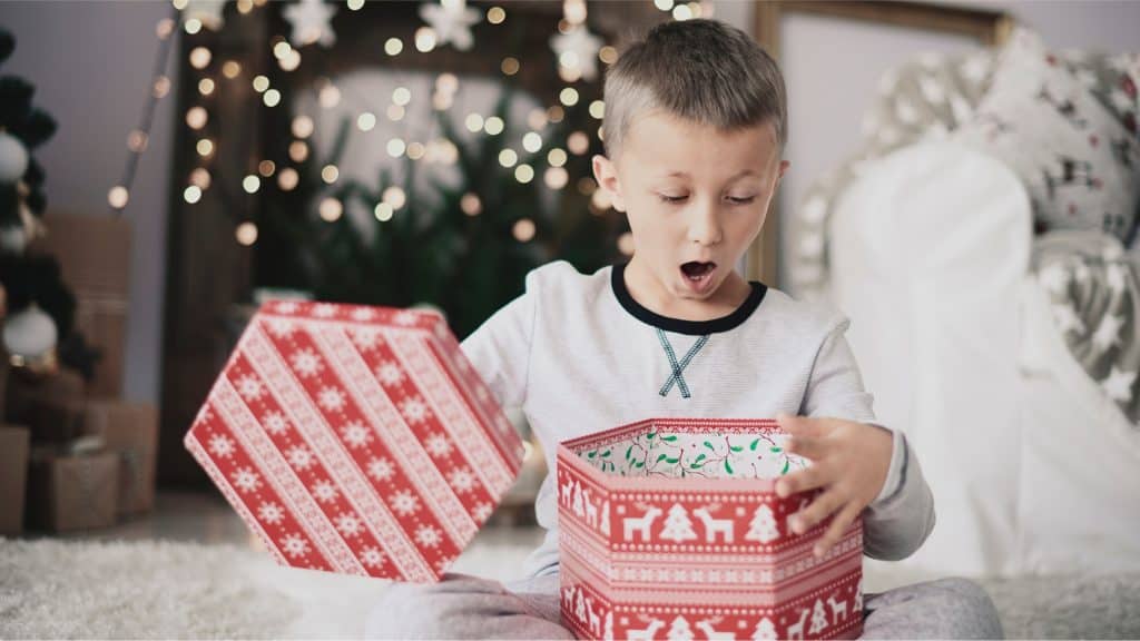 boy looking surprised as he opens gifts
