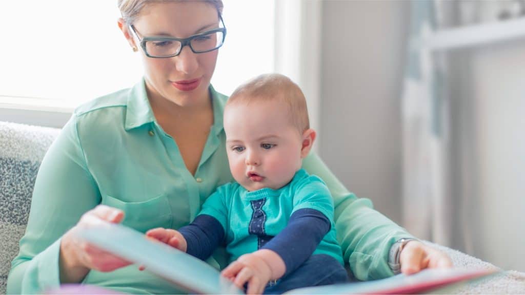 mom demonstrating the importance of reading with your children by reading to her baby