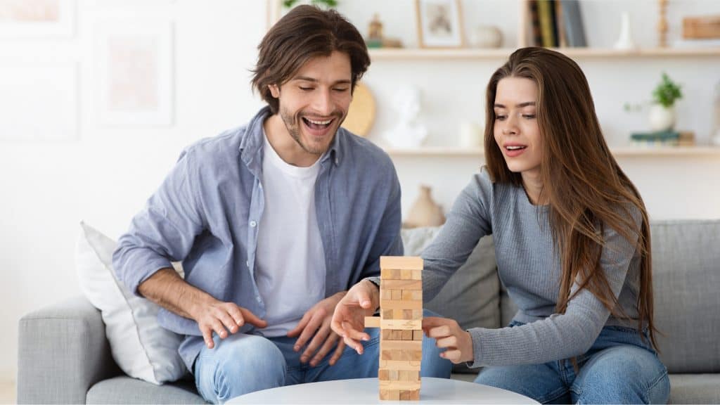 couple playing jenga which is one of the best two person games for couples to play