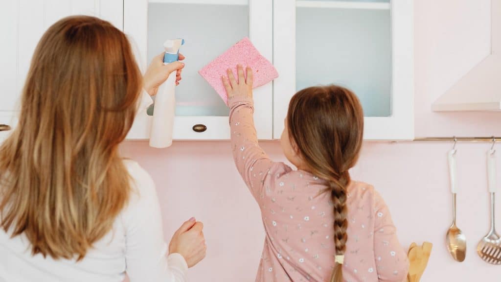 mom and daughter cleaning the cabinets