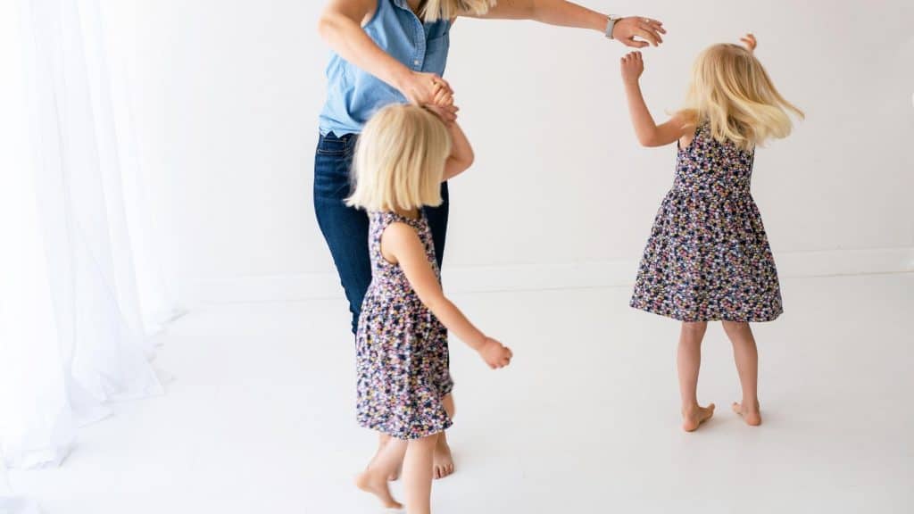 mom dancing with twin daughters as her new years resolution