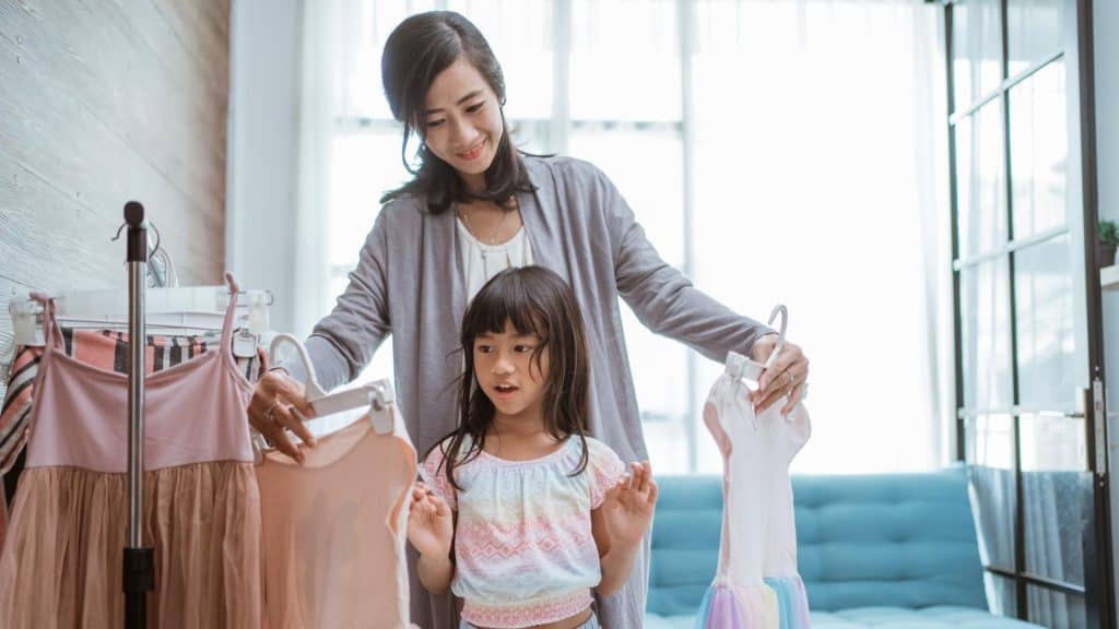 mom and daughter picking out clothes as part of her working mom routine