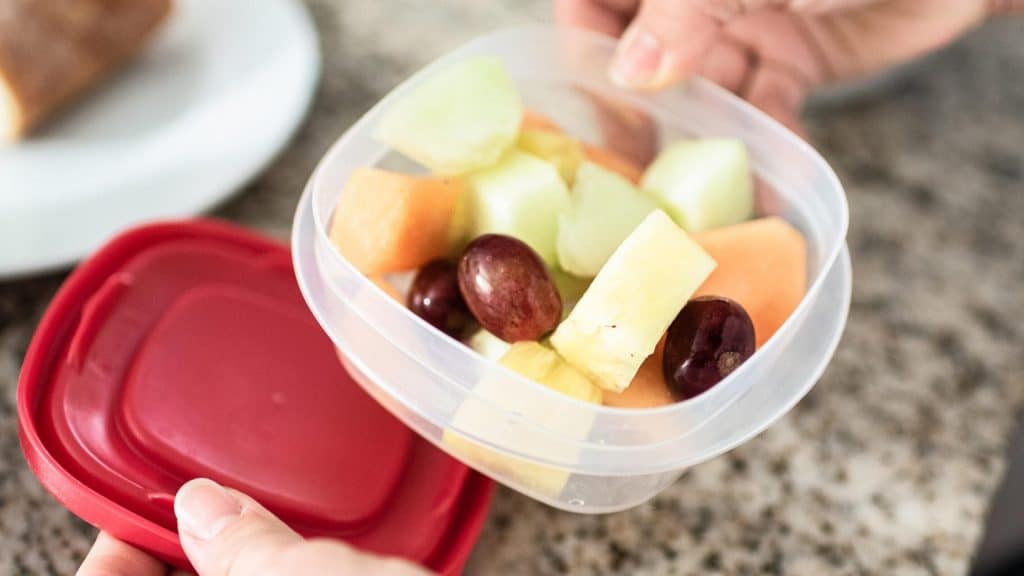 mom packing fruit snacks in container ahead of time